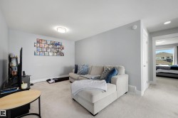 Carpeted living area with light gray walls, white baseboards, and a flush mount ceiling light - 
