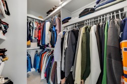 Integrated closet system with multiple hanging rods, overhead shelving, and built-in shelving units - 