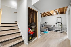 Finished lower level with light wood-finish flooring, white walls, and an open-concept layout - 