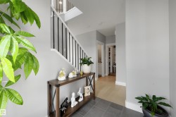 Entryway featuring a modern staircase with black vertical balusters and white risers - 