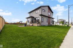 Contemporary two-story residence featuring grey horizontal siding and dark accent paneling - 
