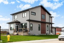 Contemporary two-story residence with gray siding and contrasting dark brown panel accents - 