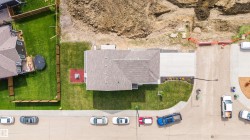 Newly constructed property featuring a gray shingle roof, well-maintained lawn, and a concrete driveway - 