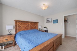 Bedroom featuring neutral wall paint, textured carpet flooring, and a flush-mount ceiling light fixture - 