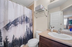 Bathroom featuring a dark wood-finish vanity with an integrated sink, chrome faucet, and a textured countertop - 