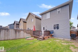 Expansive backyard featuring a manicured lawn, wood fencing, and a built-in wooden deck - 