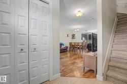 Entryway featuring bi-fold panel doors, tiled flooring, and a carpeted staircase - 