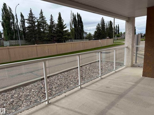 Concrete patio featuring a glass and white metal railing system - 118 7801 Golf Course Road, Stony Plain, AB 