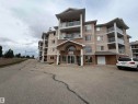 Multi-story building featuring stucco exterior and multiple private balconies with glass railings - 118 7801 Golf Course Road, Stony Plain, AB 
