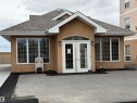 Stucco exterior building with a prominent arched double-door entry - 118 7801 Golf Course Road, Stony Plain, AB 