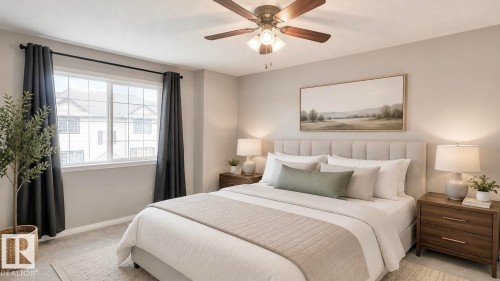 Bright bedroom featuring a large window, neutral wall tones, and carpeted flooring - 9 225 Blackburn Drive E, Edmonton, AB 