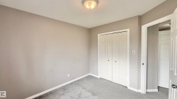 Neutral-toned room featuring a flush-mount ceiling light, paneled bi-fold closet doors, and light gray wall-to-wall carpeting - 