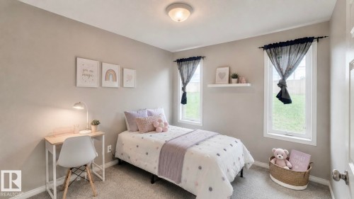 Carpeted room featuring two single-pane windows, a ceiling-mounted light fixture, light gray walls, and white baseboards - 9 225 Blackburn Drive E, Edmonton, AB 