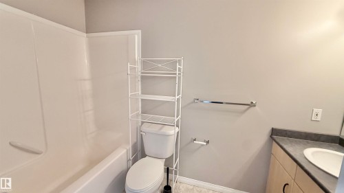 White bathtub and shower surround with light gray walls - 9 225 Blackburn Drive E, Edmonton, AB 