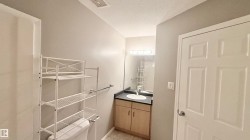Contemporary bathroom featuring a light wood-finish vanity with a dark countertop and an undermount sink - 