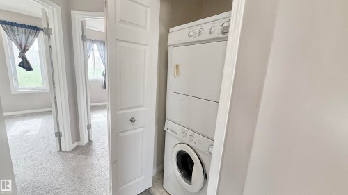 Dedicated laundry closet featuring a stacked washer and dryer - 9 225 Blackburn Drive E, Edmonton, AB 
