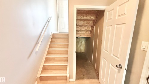 Hardwood staircase with white wall-mounted handrail - 9 225 Blackburn Drive E, Edmonton, AB 