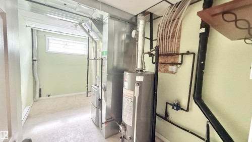 Utility room featuring a water heater, furnace, and exposed ductwork - 9 225 Blackburn Drive E, Edmonton, AB 