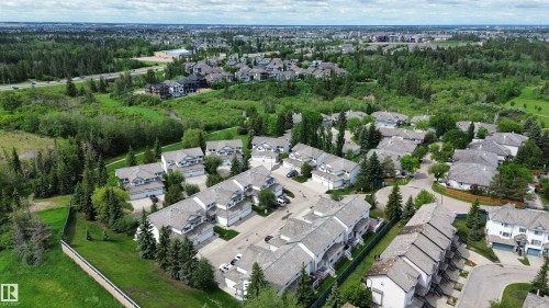 Aerial perspective showcasing a residential community surrounded by extensive green spaces and mature trees - 9 225 Blackburn Drive E, Edmonton, AB 