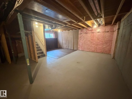 Basement space featuring exposed ceiling joists, concrete flooring, and partial wall insulation - 6821 Evans Wynd, Edmonton, AB 