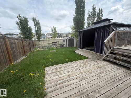 Expansive backyard featuring a multi-level wooden deck, a covered gazebo, and a storage shed - 6821 Evans Wynd, Edmonton, AB 