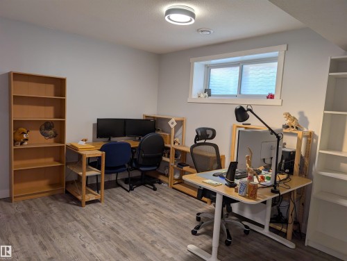 Versatile room featuring light wood-finish flooring, a contemporary flush-mount ceiling light, and a recessed window with white trim - 9240 224 Street Nw, Edmonton, AB - Indoor Photo Showing Gym Room