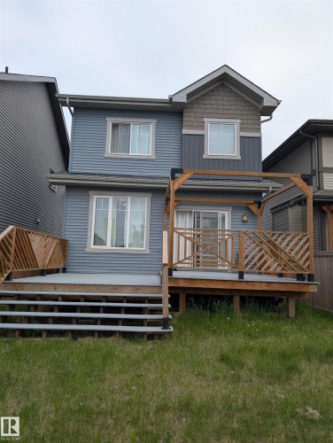 Rear exterior featuring two-story construction with blue siding - 9240 224 Street Nw, Edmonton, AB - Outdoor With Deck Patio Veranda