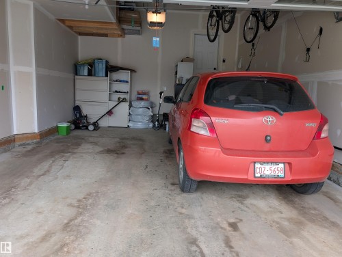 Garage space featuring a concrete floor, painted drywall, and overhead lighting fixtures - 9240 224 Street Nw, Edmonton, AB - Indoor Photo Showing Garage