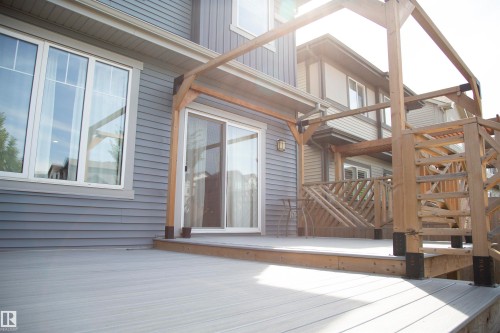 Expansive composite decking with a built-in pergola frame, sliding glass door access, and large windows - 9240 224 Street Nw, Edmonton, AB - Outdoor With Deck Patio Veranda With Exterior