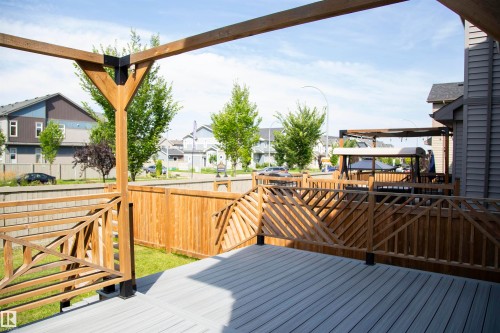 Expansive outdoor deck featuring wood-finish decking, intricate wood railings, and a wood pergola - 9240 224 Street Nw, Edmonton, AB - Outdoor With Deck Patio Veranda With Exterior