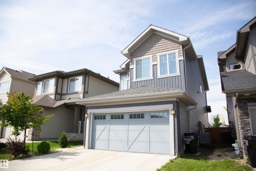 Two-story property featuring a front-facing garage, concrete driveway, and a combination of horizontal and vertical siding - 9240 224 Street Nw, Edmonton, AB - Outdoor