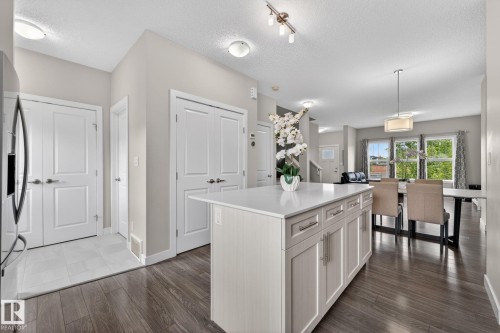 Central kitchen island featuring a light-toned countertop and cabinetry with contemporary hardware - 165 Robinson Drive, Leduc, AB 