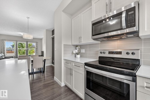 Kitchen featuring stainless steel appliances, light cabinetry, white countertops, and a subway tile backsplash - 165 Robinson Drive, Leduc, AB 