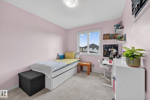 Bright interior room with textured carpeting and soft pink wall paint - 165 Robinson Drive, Leduc, AB 