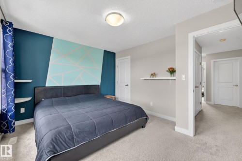 Neutral-toned carpeting extends throughout the room - 165 Robinson Drive, Leduc, AB 