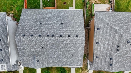 Grey asphalt shingle roofing on a multi-pitched roofline - 165 Robinson Drive, Leduc, AB 