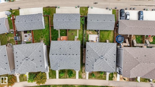 Aerial perspective showcasing multiple residential properties with grey shingle roofing - 165 Robinson Drive, Leduc, AB 