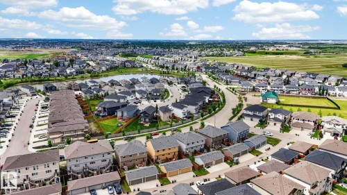 Residential community featuring diverse home styles, a central pond, and curving street layouts - 165 Robinson Drive, Leduc, AB 