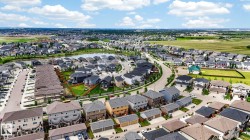 Residential community featuring diverse home styles, a central pond, and curving street layouts - 
