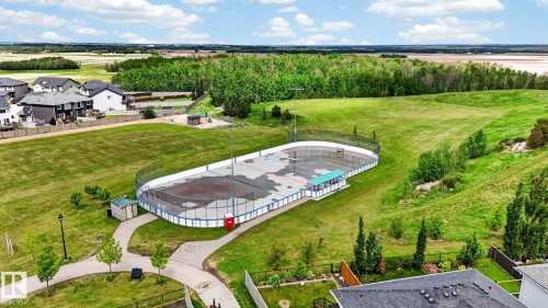 Outdoor recreational court with surrounding fence and green space - 165 Robinson Drive, Leduc, AB 