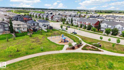 Expansive green space featuring a playground with slides and swings - 165 Robinson Drive, Leduc, AB 
