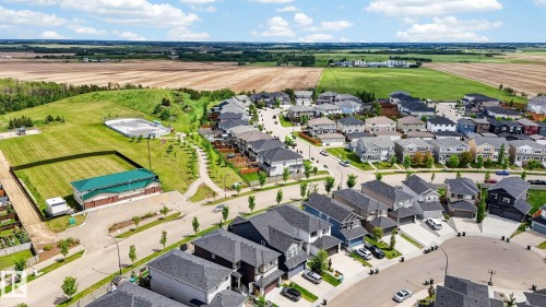 Modern residential development featuring a collection of detached homes with varied architectural styles and dark-toned roofs - 165 Robinson Drive, Leduc, AB 