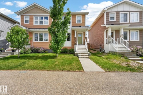 Two-story residence featuring light orange siding and white trim - 165 Robinson Drive, Leduc, AB 