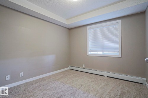 Neutral-toned walls complement plush carpeting - 405 11804 22 Avenue Sw, Edmonton, AB 
