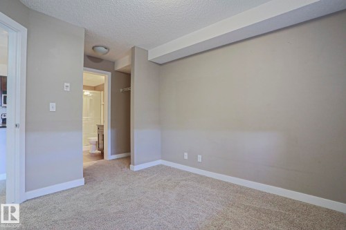 Carpeted interior space with light gray wall paint and white trim - 405 11804 22 Avenue Sw, Edmonton, AB 