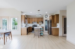 Open-concept living space with light wood-finish flooring - 