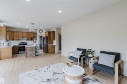 Open-concept living space featuring wood-finish flooring, recessed lighting, and a neutral color palette - 