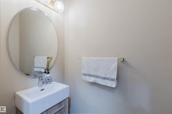 Modern vanity featuring a rectangular ceramic sink, chrome faucet, and wood-finish cabinetry - 