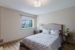 Spacious room featuring wood-finish flooring, neutral-toned walls, and a large window - 