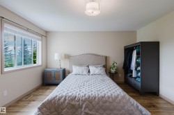 Spacious room featuring wood-finish flooring, a large window, and light-toned walls - 